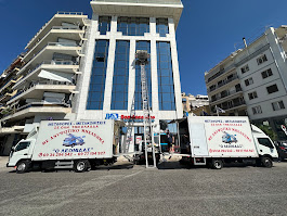 Ανυψωτικό μετακόμισης και φορτηγά έξω από κτίριο γραφείων στην Αθήνα